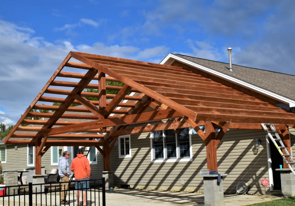 Wooden pergola under construction on house.